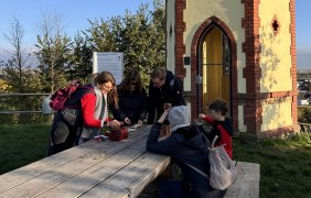 Gruppe von Menschen spielt vor Rotem Häuschen © We Escape